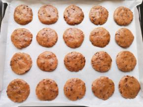 烤盘里铺上油纸，搓好的面团压扁成饼干状，摆入烤盘。 烤箱上管170度下管165度预热。 