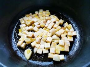 锅内热油，爆香大蒜，加入杏鲍菇炒出汁，
