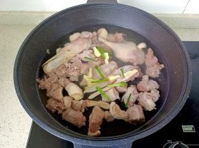 焯好水的鸭肉重新放入冷水里，加生姜片，葱。