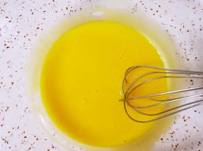 蛋黄用手动打蛋器打散,加入玉米油搅打均匀。 