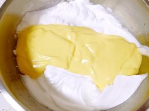 把翻拌好的蛋黄糊倒入剩下的蛋白中间，继续翻拌均匀，烤箱上管150度，下管165度预热。
