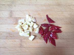 大蒜切成小丁，干红辣椒切成段。 