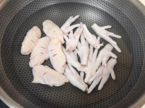 鸡爪鸡翅凉水入锅，加入料酒焯水。 