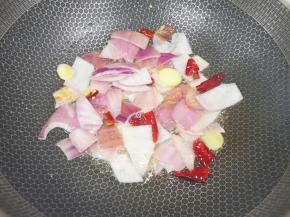 炒锅内倒适量的菜籽油烧热，下入洋葱、姜片和干红辣椒炒香。 