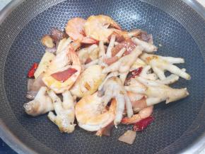 下入焯过水的鸡爪鸡翅翻炒至表面微微焦黄。 