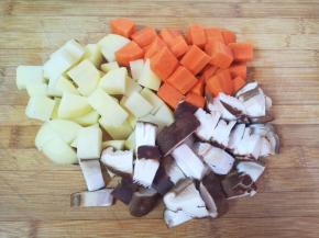 准备配菜:土豆、胡萝卜和香菇分别切成小块。 