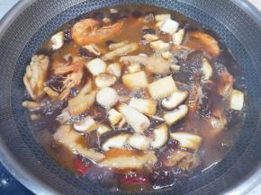 20分钟以后下入鱼丸和香菇，翻炒均匀炖8分钟。 