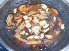 20分钟以后下入鱼丸和香菇，翻炒均匀炖8分钟。 