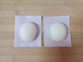 将白色的的面团分成6等分，揉成椭圆形的面团放在油纸上，做成冰墩墩的身体。