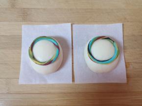 将彩色的长面条截取一段，做成一个圆形的彩圈沾点水粘在冰墩墩的身体上。