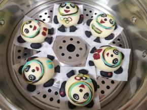 依次做好剩下的几个冰墩墩馒头，蒸锅里放水放篦子，将做好的冰墩墩馒头移至篦子上，盖上锅盖发酵20分钟。