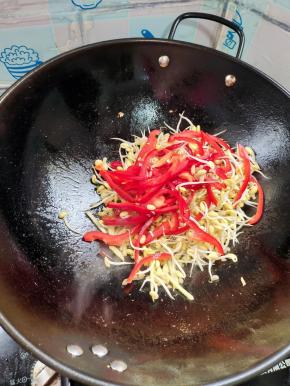 放入黄豆芽和红辣椒炒至断生！