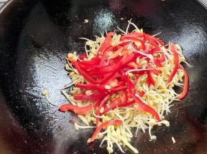 放入黄豆芽和红辣椒炒至断生！
