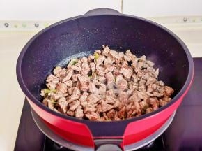 切好的葱姜放锅中加入腌制好的牛肉翻炒至变色。