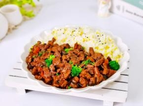 盘中一半饭撒上熟黑芝麻，一半菜放上焯水的西兰花。