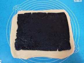 再次擀开成长方形的面片，放上黑芝麻馅擀开。