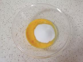 玻璃碗中打入一个鸡蛋，加入细砂糖。