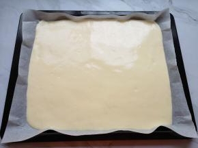 烤盘里铺上油纸，倒入蛋糕糊，用刮刀刮平表面，轻震几下震出大气泡。