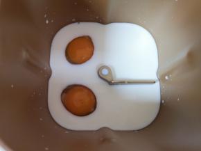 面包机桶内加入牛奶，打入2个鸡蛋。