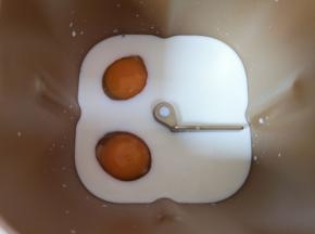 面包机桶内加入牛奶，打入2个鸡蛋。