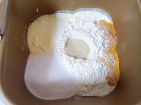 加入高筋面粉、奶粉、细砂糖和蜂蜜，面粉中间挖个小坑放入发酵粉盖起来。