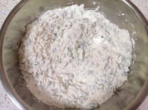 将碎苜蓿菜放入盆里，加入中筋面粉搅拌均匀。