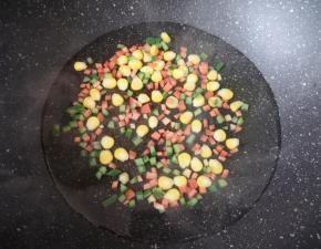 锅里放水烧开，先下入玉米粒焯熟关火，再下入红萝卜和黄瓜丁一起烫一下。