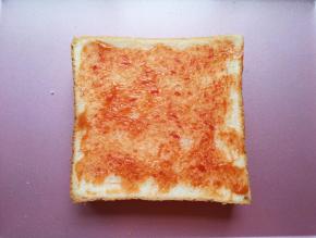 盖上另一片吐司，抹上一勺番茄酱。