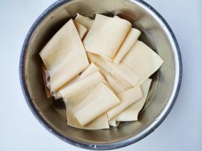 豆皮切成宽长条，温水泡开洗净。
