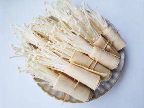 取一小把金针菇放在豆皮上卷起来，用牙签固定。