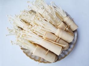 取一小把金针菇放在豆皮上卷起来，用牙签固定。