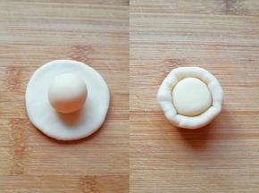 取一个油皮面团压扁，放上一份油酥面团，用虎口慢慢向上推挤收口。 