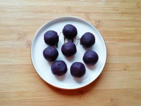 将紫薯馅分成8份搓圆， 烤箱上下管180度预热。 