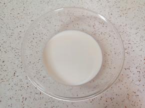 玻璃盆中加入纯牛奶。 