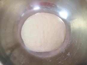 加入中筋面粉，用筷子搅拌成絮状，揉成光滑的面团，盖上保鲜膜发酵至两倍大。 