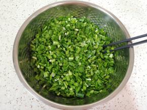 控干水分的韭菜切碎，加入香油搅拌均匀（让油先裹住韭菜，这样韭菜就不容易出水了），静置一会儿。 
