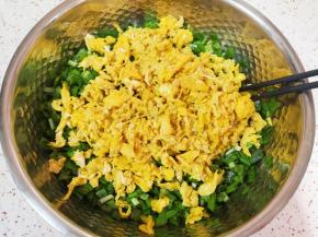 将炒好的鸡蛋加入韭菜里面。 