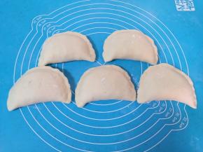 将馅料放在面皮的一边，把另一半面皮盖过来，捏紧封口。 