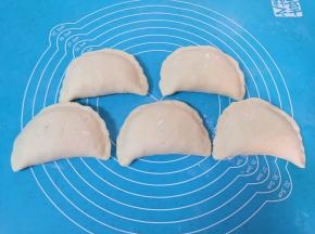 将馅料放在面皮的一边，把另一半面皮盖过来，捏紧封口。 