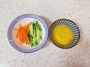 胡萝卜和黄瓜分别切成丝，鸡蛋打散。 