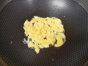 炒锅内倒适量的菜籽油烧热，倒入蛋液翻炒成块状。 