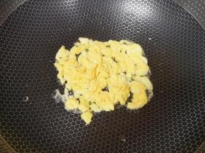 炒锅内倒适量的菜籽油烧热，倒入蛋液翻炒成块状。 