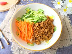 煮好的面条盛入碗中，放上胡萝卜黄瓜丝，浇上鸡蛋酱。 