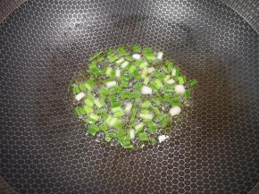 炒锅内倒适量的花生油烧热，下入葱段炒香。 