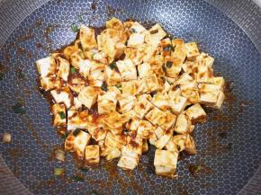 下入焯过水的豆腐翻炒均匀。 