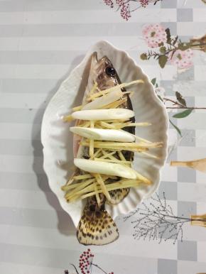 把腌制好的鲫花鱼放在筷子上，再放入适量的姜丝和葱段！