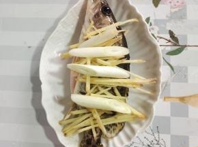 把腌制好的鲫花鱼放在筷子上，再放入适量的姜丝和葱段！