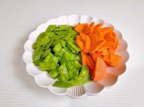 荷兰豆洗净去跟去尖，切小段，胡萝卜去皮切片。