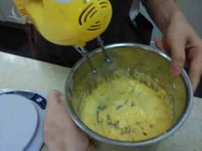 加入蛋黄液，不开打蛋器搅搅，再通电用1档打发均匀（注：中间用刮刀把壁上的黄油弄下来，再开打蛋器搅匀）。