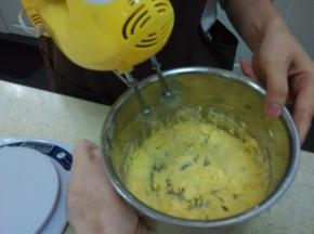 加入蛋黄液，不开打蛋器搅搅，再通电用1档打发均匀（注：中间用刮刀把壁上的黄油弄下来，再开打蛋器搅匀）。